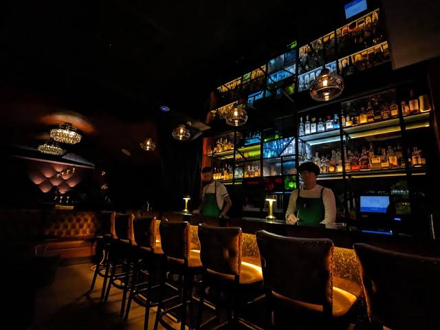 The dark gold-lit interior of Bijou Drinkery Room in Hipodromo