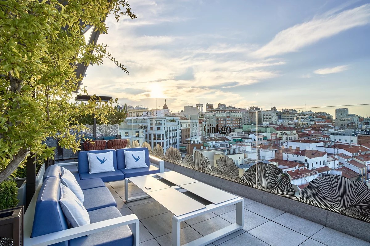 The terrace at Ginkgo Sky Bar in Madrid looking west over rooftops at sunset