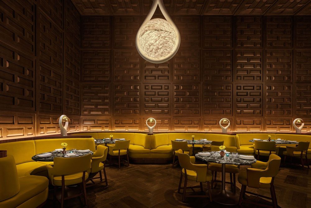 The dining room at Jeronimo, The Madrid EDITION, with yellow banquettes and carved wood walls