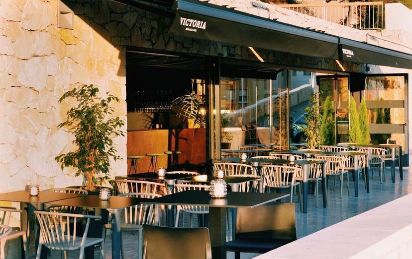 The terrace at Mi Nina Lola in Malaga, with wicker chairs under awnings in the evening light